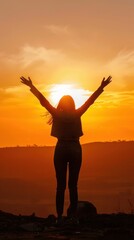 Fototapeta premium silhouette of a happy woman spreading her arms in the sky at sunset