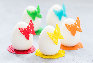Easter Mousse Cream chocolate cake in the shape of an Easter egg, decorated with colorful waffle lace decor, with a butterfly and a napkin. Light background.  Close up