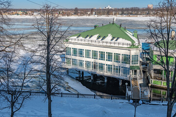 House on the water near the river bank among ice floes.