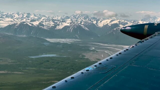 ABeechcraft Bonanza airplane wingtip flies over Lake Clark Pass in Alaska. Mount Redoubt in the background. Small aircraft are only way to see many areas of Alaska.