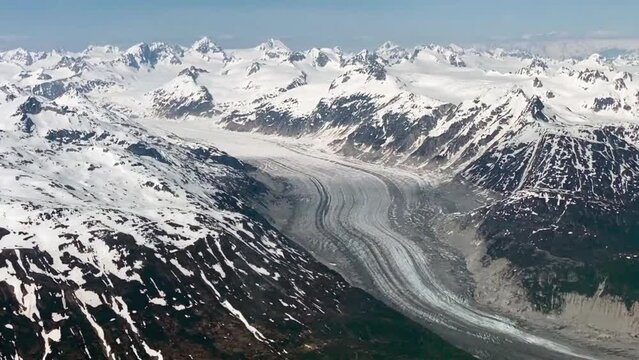 Glacier seen from small airplane in Lake Clark Pass, Alaska. Dark debris lines called lateral or medial moraines along the edges and down the center of glacier. 