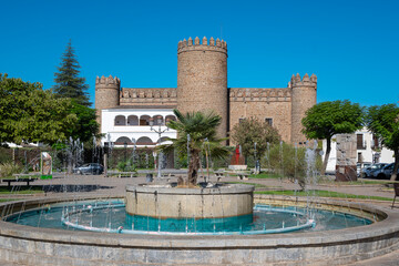 Fuente en la plaza del alcázar con el palacio de los  Duques de Feria, hoy parador nacional de...