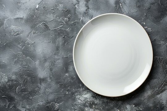 A white porcelain plate placed on a wooden table, ready to be filled with food or used for a meal