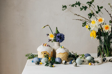 Happy Easter! Stylish easter eggs, homemade easter bread and spring flowers on linen napkin on...