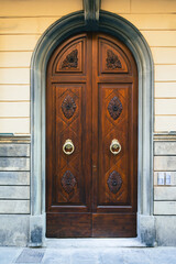 Elegant old double door entrance of brick pink building in Europe. Vintage wooden doorway of ancient stone house. Simple brown wood door. Architecture in Italy.