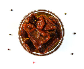 Plate with dried tomatoes in oil isolated on white background with pepper, top view. Healthy food. Great snack.