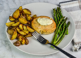 salmon buger ith potato wedges and sauteed asparagus