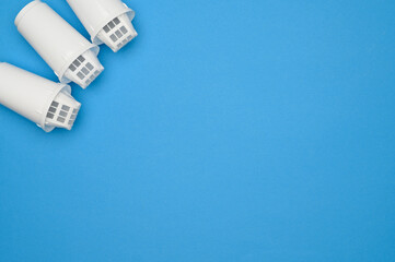 Layout :new three filter cartridges for clean water on a blue background, top view. Concept of a...