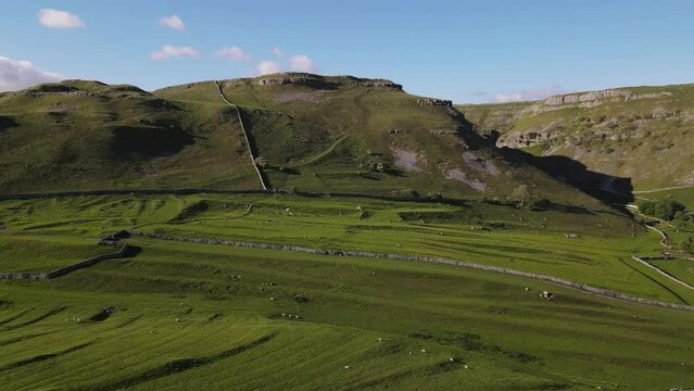 Drone footage shows green meadows and fields specific to Yorkshire in the Yorkshire Dales near Malham, Skipton, North Yorkshire UK