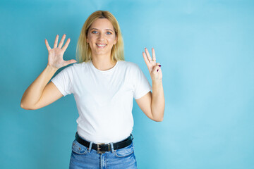 Young beautiful woman wearing casual t-shirt over isolated blue background showing and pointing up with fingers number eight while smiling confident and happy