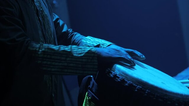 Black man playing typical african instrument on stage (djemb&eacute;)