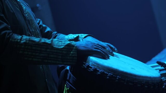 Black man playing typical african instrument on stage (djemb&eacute;)