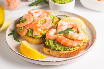 Shrimps on toast with avocado and lemon. Breakfast concept. Bruschetta. 