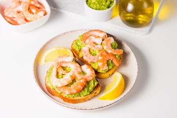 Shrimps on toast with avocado and lemon. Breakfast concept. Bruschetta. 