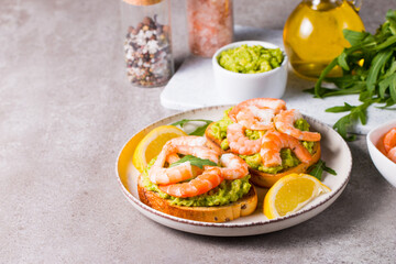 Shrimps on toast with avocado and lemon. Breakfast concept. Bruschetta. 