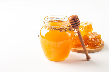 Honey dripping from a wooden honey dipper on white background. Healthy organic food concept. 