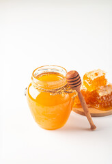 Honey dripping from a wooden honey dipper on white background. Healthy organic food concept. 
