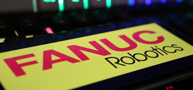 Viersen, Germany - March 1. 2024: Closeup of smartphone with logo lettering of Fanuc Robotics on computer keyboard