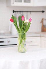 Home kitchen interior.Vase with bouquet of pink white tulips on table. Spring consept.