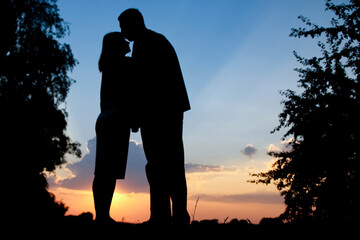 happy couple together at sunset silhouette of nature