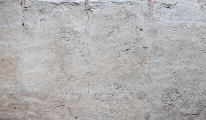 Old ancient wall with damaged gray plaster.