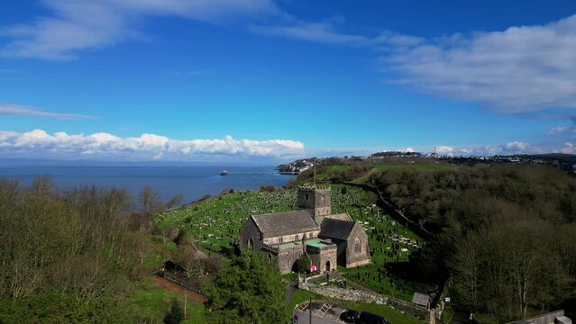 Aerial view of St. Andrews Church, cemetery, and Poets walk in Clevedon, Somerset filmed by 4K drone