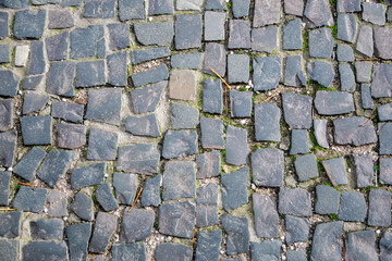 Stone wall with old bricks in the city. Gray stone block surface.