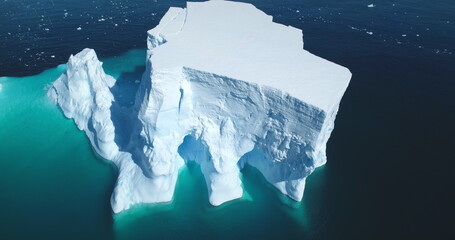 Antarctica giant iceberg melting in blue water aerial top view. Nature beauty of towering glacier cavity arctic ice. South Pole winter scene. Ecology climate change, global warming concept. Drone shot
