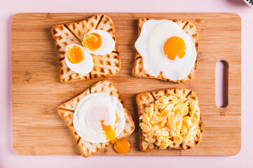 Fototapeta na wymiar Homemade scrambled egg, poached egg, fried egg, boiled egg on toast on a board top view