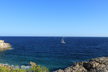 Velero en el horizonte del mar azul con cielo azul
