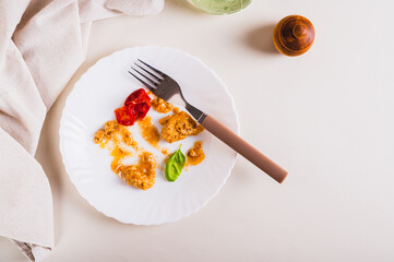 Stop food waste. Leftover food on a plate after dinner on the table top view