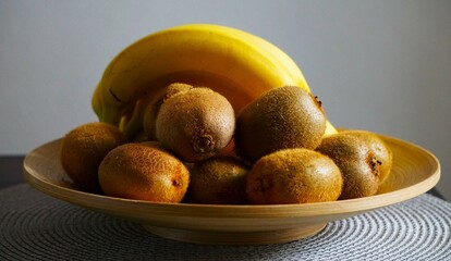 Pełny talerz z najróżniejszymi owocami. Na talerzu leżą dojrzałe banany i kiwi. © Adam