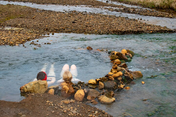 Relaxing Soak in Nature: Two Women Enjoying Reykjadalur Hot Spring Thermal River, Iceland