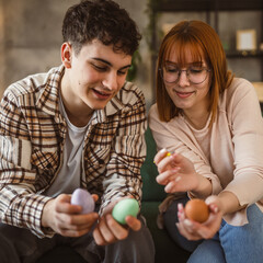 young man and woman couple or brother and sister paint easter eggs