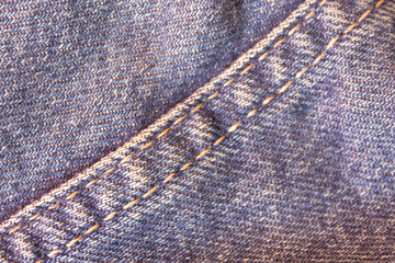 Close-up texture of a denim fabric emphasizing the stitched seam