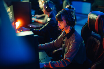 Female gamer playing multiplayer video game with her friends in a gaming club © Zamrznuti tonovi
