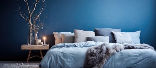 A close-up of a bedroom with blue walls and a sizable bed dominating the space. The room exudes a serene and minimalist Scandinavian design aesthetic.