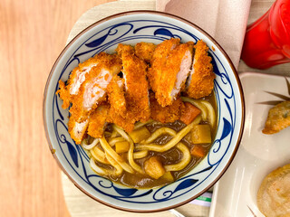 A bowl of chicken katsu curry with udon noodles at a Japanese restaurant