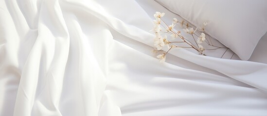 A detailed view of a neatly made bed with crisp white sheets and fluffy pillows. The white bedding creates a clean and inviting atmosphere in the room.