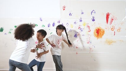 Playful children playing and running with colorful stained hand in front of white background. Funny...