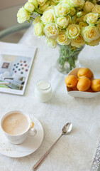 A cup of delicious morning coffee with organic yogurt, apricots and a bouquet of cream roses in the background. Selective soft focus - 755176705