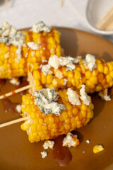 Hot boiled corn with bright yellow grains with Homemade salted caramel sauce and cheese. sweet and salty unusual dessert. 