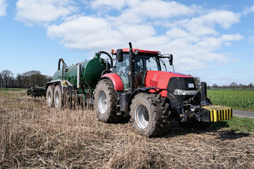 Obraz premium Ausbringung von Gärresten und Gülle einer Biogasanlage aufs Feld im Frühjahr, warten am Wegesrand auf Gülle-Nachschub.