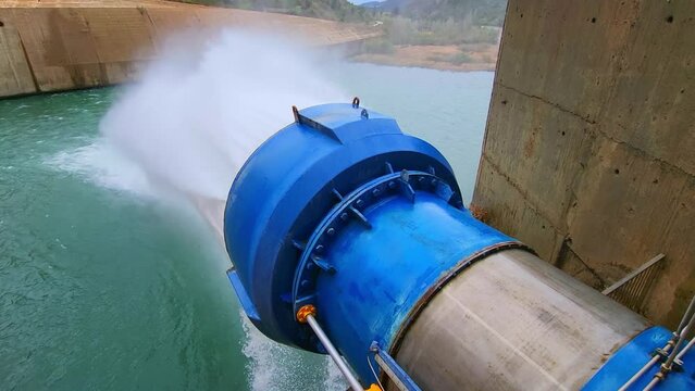 Water outlet from dam wall. Howell Bunger valve in operation. Pressurized water outlet from dam wall. Water flowing from pumping in reservoir.