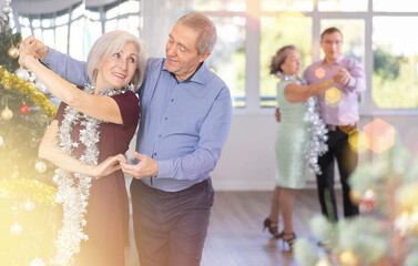 Elderly man and elderly woman dance ballroom dance waltz in studio