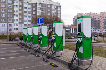 Car parking with charging stations near a multi-storey apartment building.