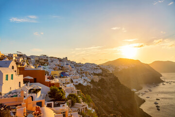 Aerial drone view of famous Oia village with white houses and blue dome churches during sunset on...