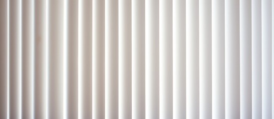 A detailed view of a window with white vertical blinds, showcasing the texture and pattern of the blinds as they hang vertically.