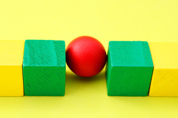 Red sphere trapped between two green cubes
