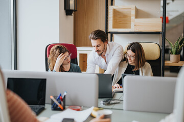 Focused group of colleagues engaging in problem-solving at a cluttered office workspace,...